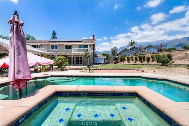 pool featuring a patio area and an in ground hot tub