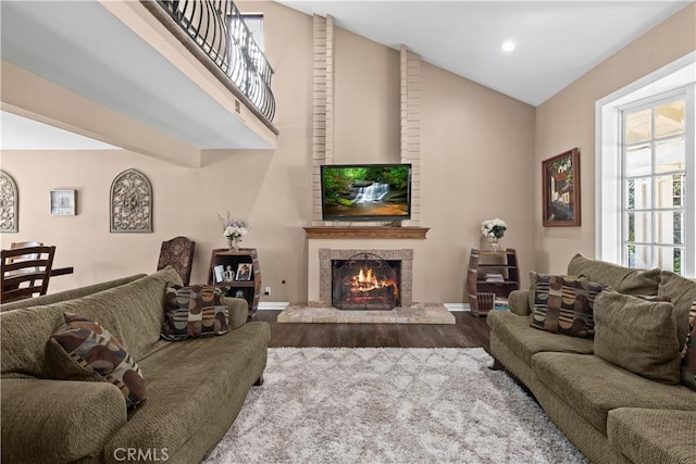 living area featuring a fireplace, recessed lighting, wood finished floors, high vaulted ceiling, and baseboards