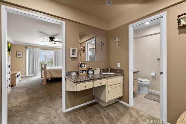 bathroom featuring baseboards, a ceiling fan, toilet, ensuite bath, and vanity