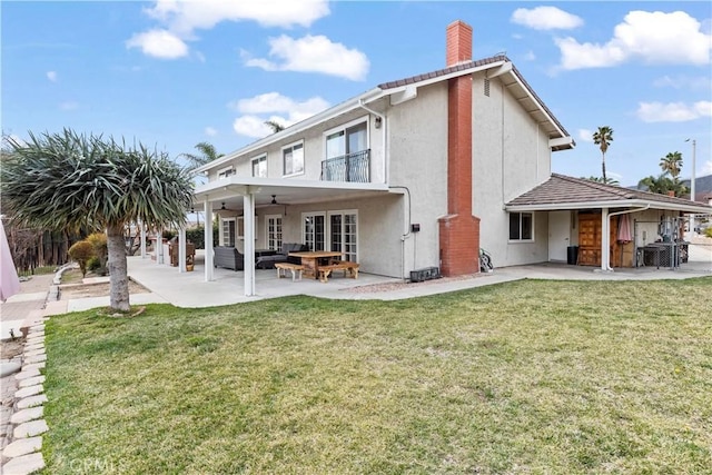 back of property with a yard, stucco siding, outdoor lounge area, a patio area, and ceiling fan