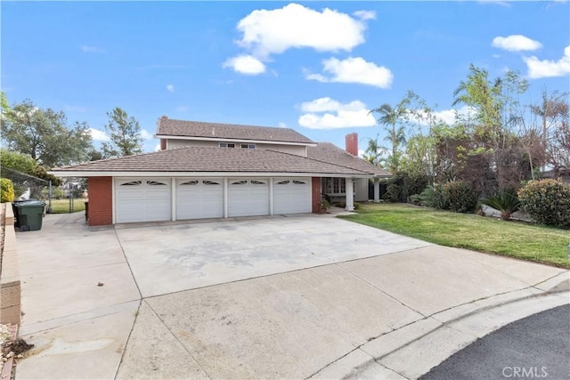 view of front of home with a garage, concrete driveway, and a front lawn