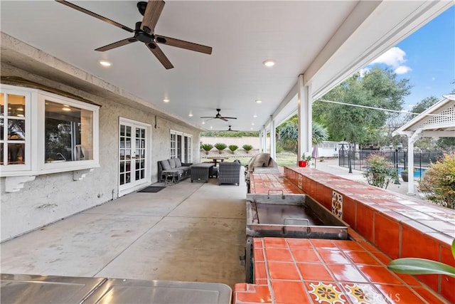 view of patio / terrace with ceiling fan, fence, outdoor lounge area, and french doors