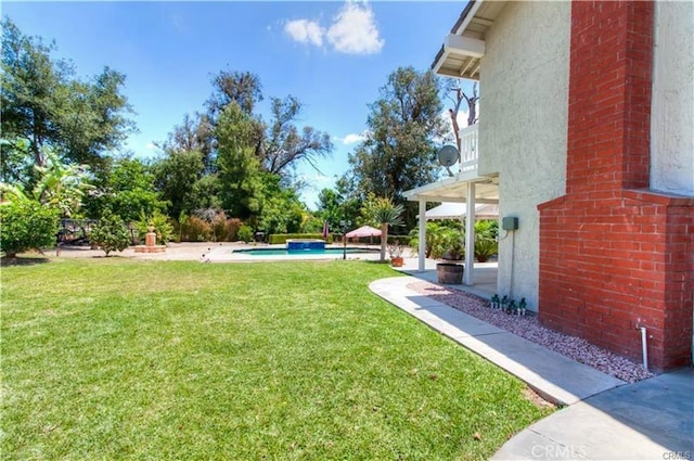 view of yard featuring a balcony, an outdoor pool, and a patio