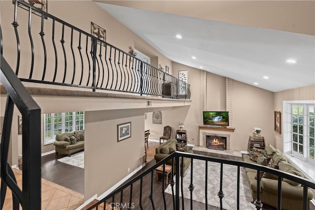 stairs featuring recessed lighting, a brick fireplace, vaulted ceiling, wood finished floors, and baseboards