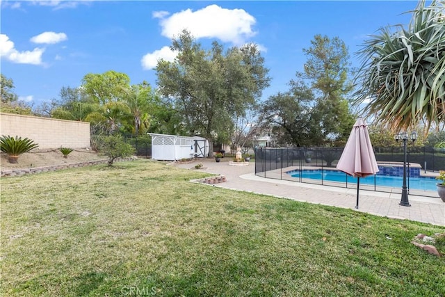 view of yard featuring an outbuilding, a fenced backyard, a fenced in pool, a shed, and a patio area