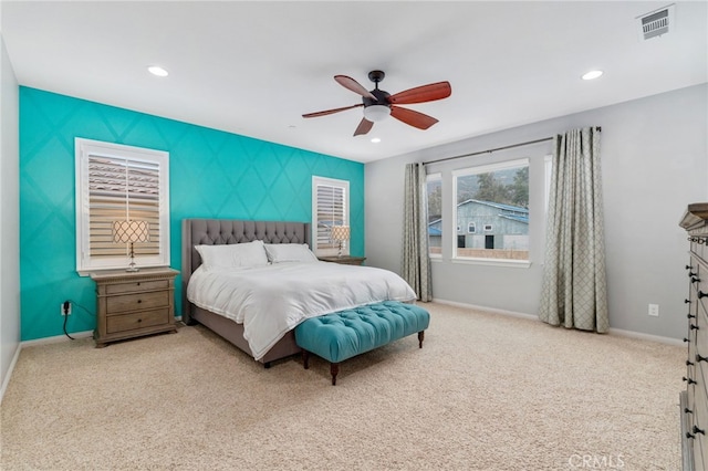 carpeted bedroom featuring recessed lighting, an accent wall, a ceiling fan, visible vents, and baseboards