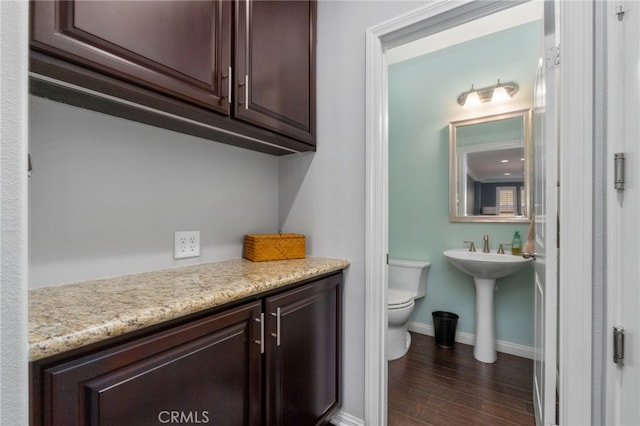 bathroom featuring toilet, baseboards, and wood finished floors