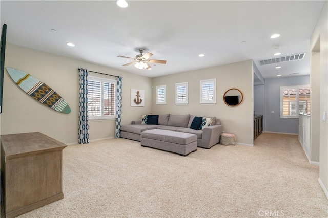 carpeted living area featuring a healthy amount of sunlight, visible vents, and baseboards