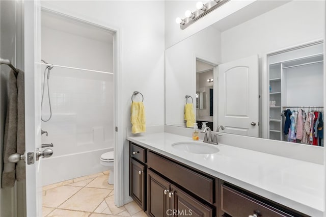 full bathroom featuring toilet, tile patterned flooring, a spacious closet, vanity, and shower / washtub combination