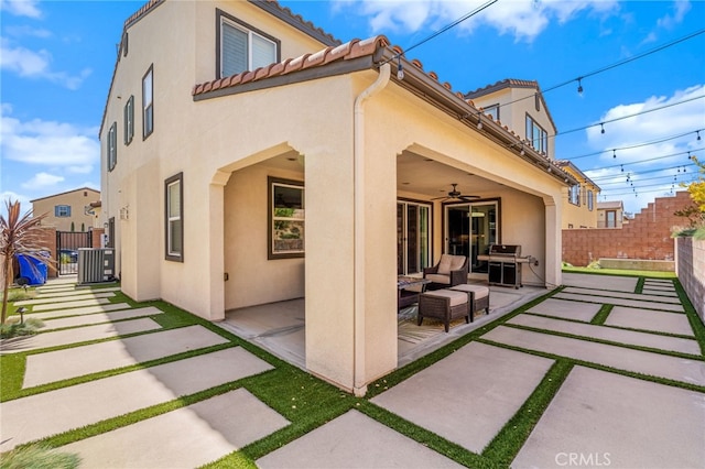 back of property with a ceiling fan, a patio, fence, and stucco siding