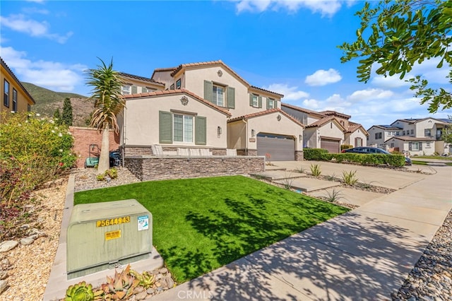 mediterranean / spanish-style house featuring stone siding, concrete driveway, a tiled roof, and stucco siding