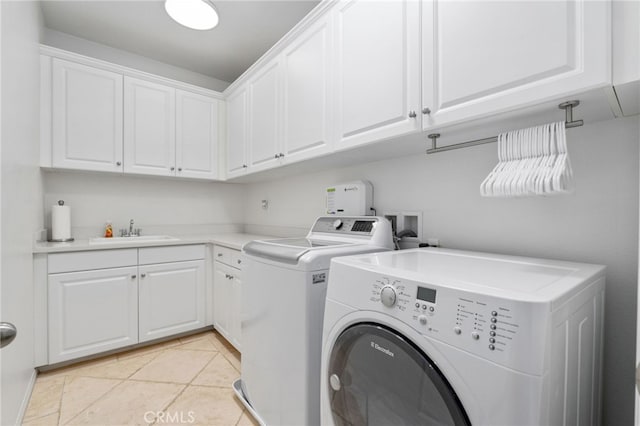 laundry room featuring cabinet space, light tile patterned floors, separate washer and dryer, and a sink