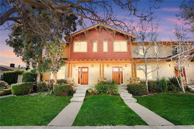 view of front of house featuring a lawn and stucco siding