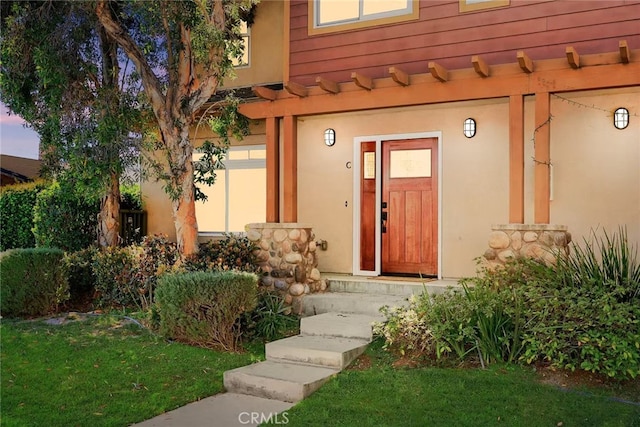 doorway to property featuring stucco siding