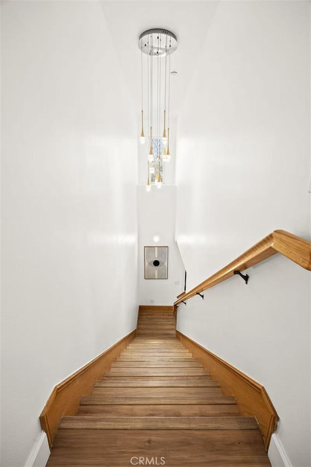 staircase with baseboards and wood finished floors