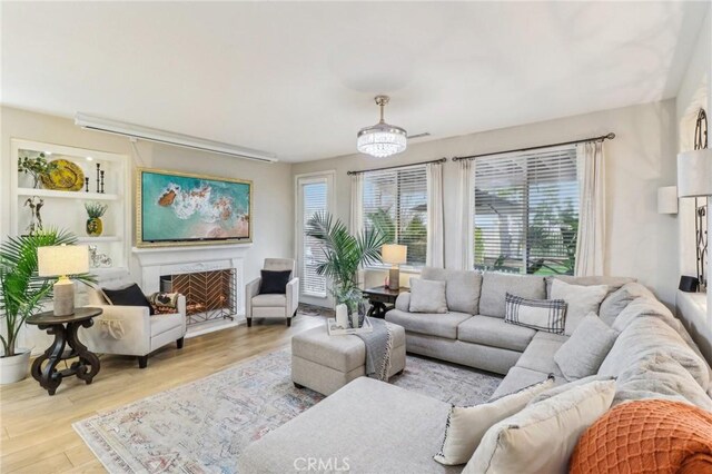 25 Vista Toscana, Lake Elsinore, CA 92532 - living area featuring wood finished floors and a warm lit fireplace