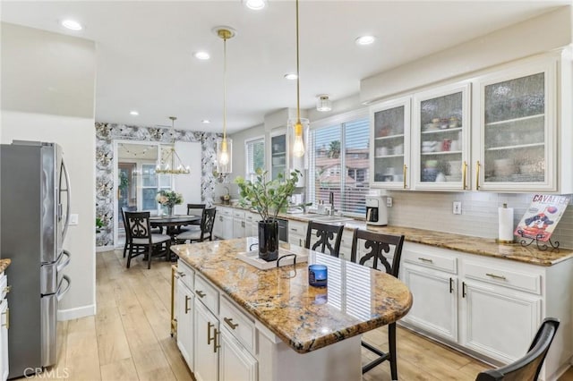 25 Vista Toscana, Lake Elsinore, CA 92532 - kitchen with freestanding refrigerator, healthy amount of natural light, a sink, light stone countertops, and recessed lighting