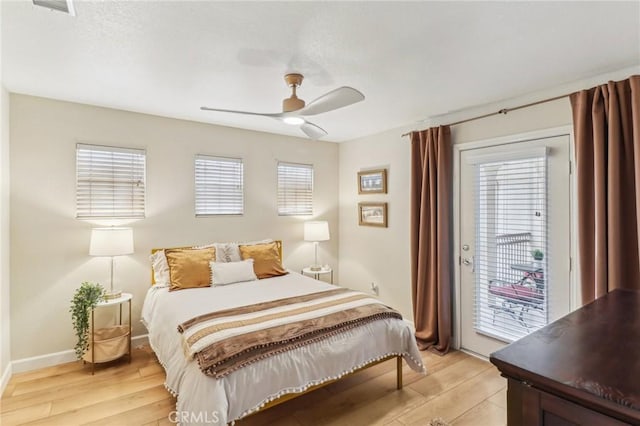 bedroom with access to outside, multiple windows, and light wood finished floors