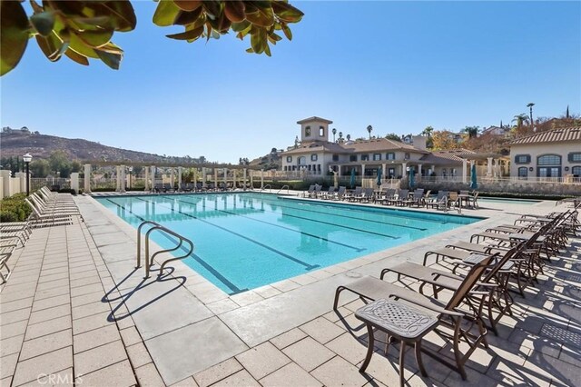 community pool with a patio and fence