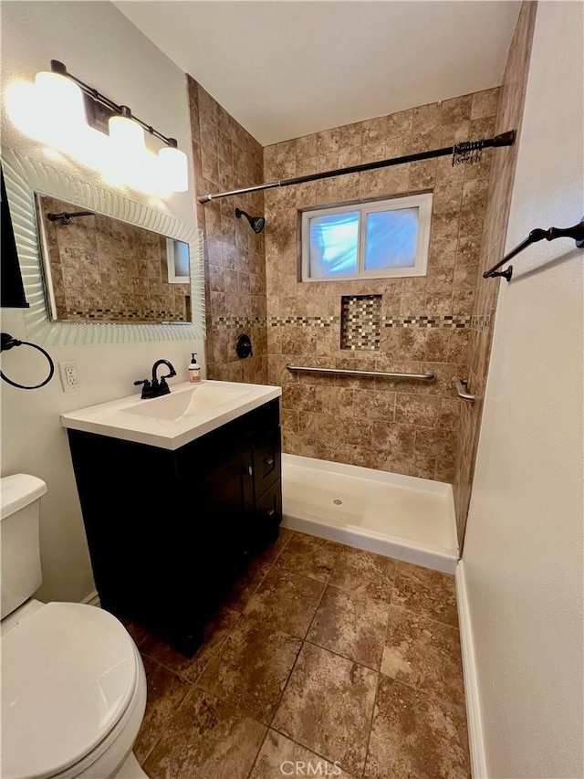 bathroom with tiled shower, toilet, and vanity