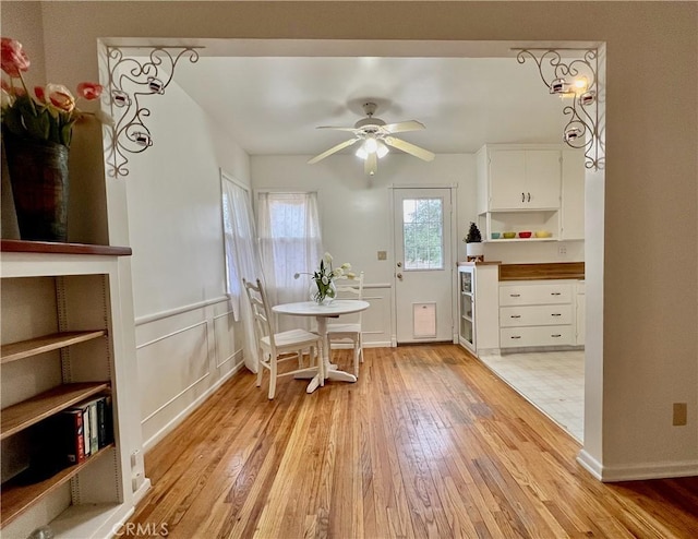 dining space with light wood-style flooring and ceiling fan