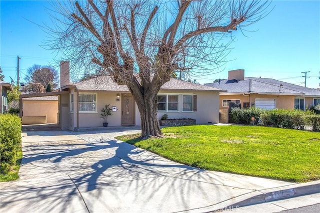 ranch-style house featuring stucco siding, driveway, and a front lawn