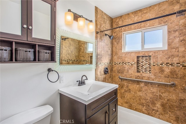 bathroom featuring vanity, toilet, and a tile shower