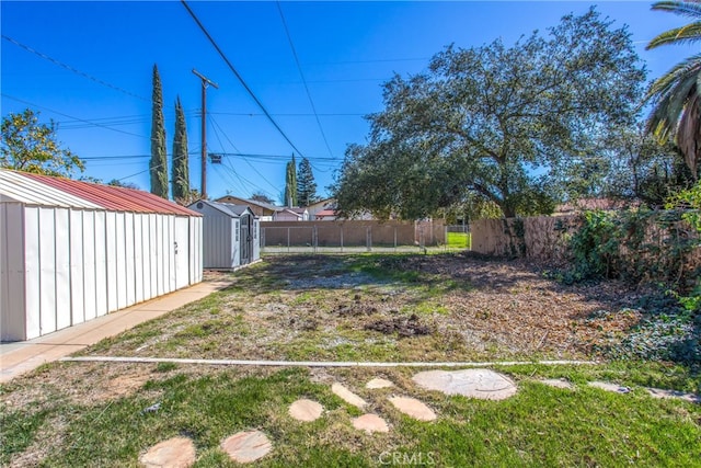 view of yard featuring an outbuilding, a shed, and fence