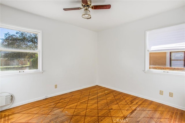 spare room featuring baseboards and a ceiling fan