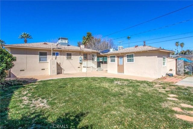 back of property featuring a lawn, central AC, and stucco siding