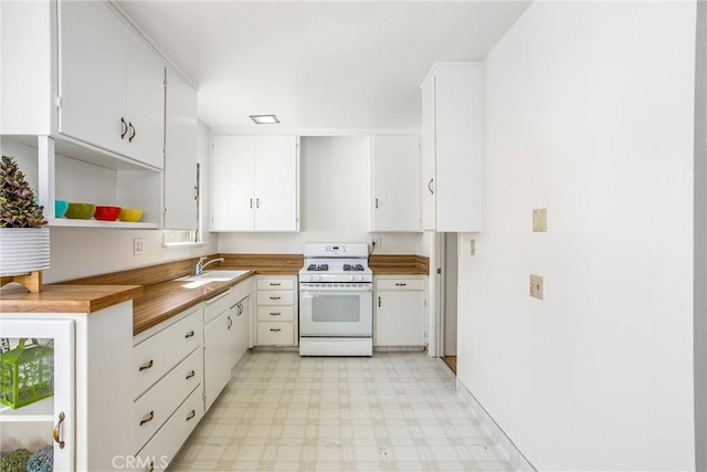 kitchen with a sink, open shelves, light floors, white cabinets, and white range with gas stovetop