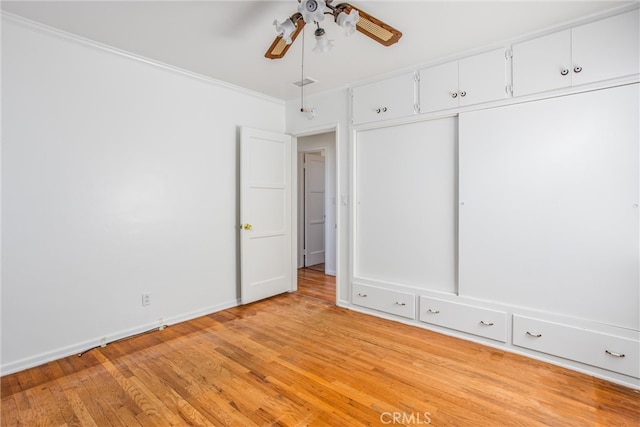 unfurnished bedroom with ceiling fan, baseboards, light wood-type flooring, and ornamental molding