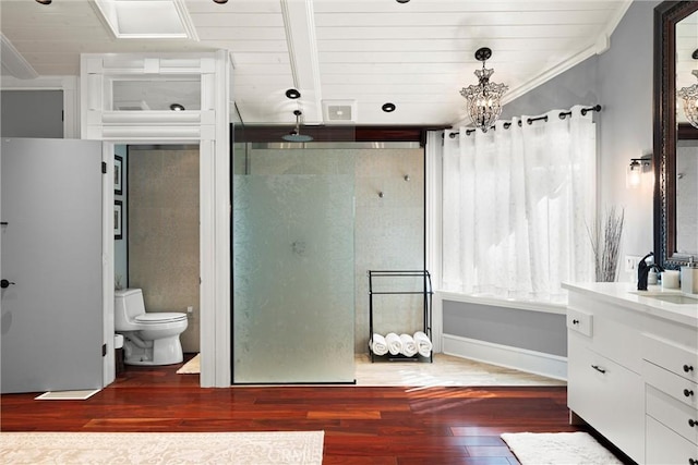 full bathroom with a shower stall, crown molding, toilet, wood finished floors, and vanity