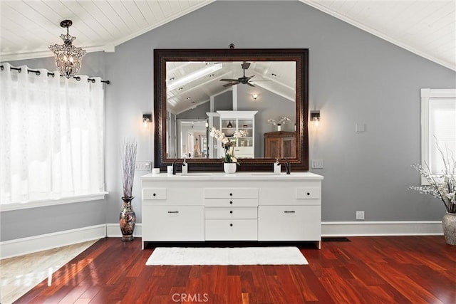 interior space with a wealth of natural light, wood finished floors, vaulted ceiling, and ceiling fan with notable chandelier