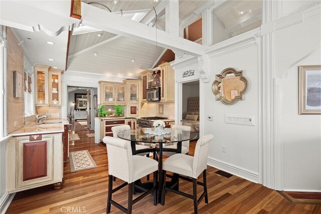 dining area with recessed lighting, vaulted ceiling with beams, visible vents, baseboards, and wood finished floors
