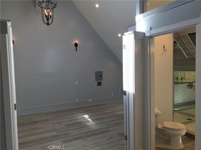 additional living space with lofted ceiling, a chandelier, electric panel, recessed lighting, and wood finished floors