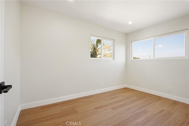 unfurnished room with light wood-type flooring, baseboards, and recessed lighting