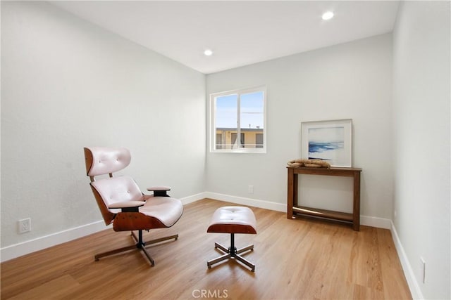 sitting room with baseboards, recessed lighting, and light wood-style floors