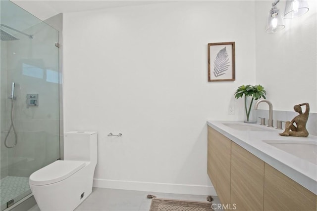 full bath featuring toilet, a stall shower, baseboards, and a sink