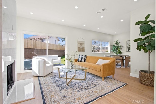 living area featuring baseboards, wood finished floors, visible vents, and recessed lighting