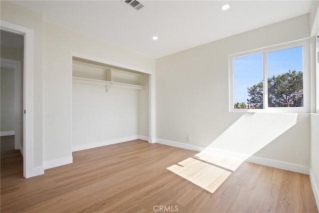 unfurnished bedroom with recessed lighting, a closet, visible vents, wood finished floors, and baseboards