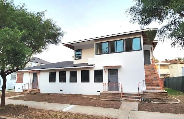 view of front of property with crawl space, fence, and stucco siding