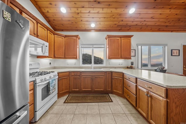 kitchen with light countertops, light tile patterned floors, wooden ceiling, a peninsula, and white appliances