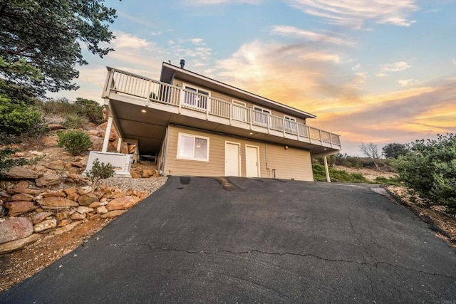 back of house featuring aphalt driveway and a wooden deck