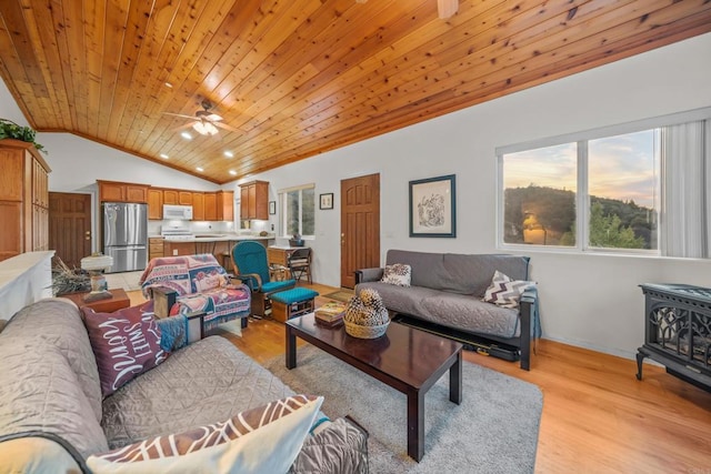 living area with light wood-style floors, wood ceiling, a wood stove, and lofted ceiling