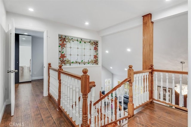 hallway with baseboards, hardwood / wood-style flooring, an upstairs landing, and recessed lighting