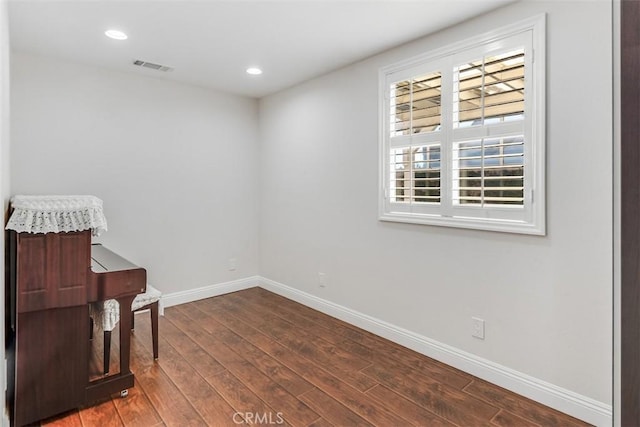 empty room featuring visible vents, recessed lighting, hardwood / wood-style flooring, and baseboards