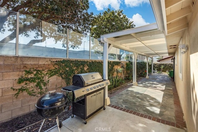 view of patio / terrace with a grill and fence