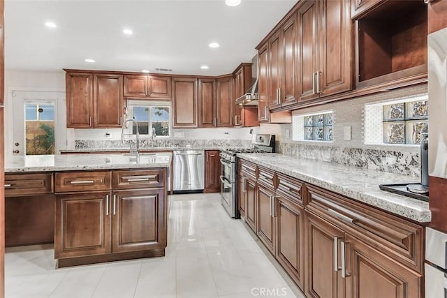 kitchen with tasteful backsplash, appliances with stainless steel finishes, recessed lighting, and light stone countertops