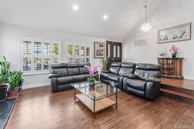 living area with high vaulted ceiling, wood finished floors, visible vents, and baseboards